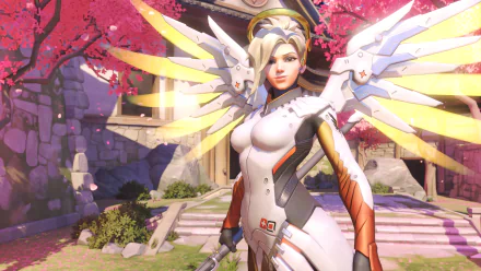 HD desktop wallpaper featuring Mercy from Overwatch, showcasing her iconic design and vibrant surroundings with cherry blossoms in a serene setting.
