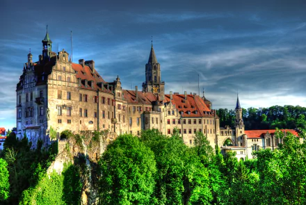 4K Ultra HD PC desktop wallpaper of Sigmaringen Castle, Germany — a man-made stone castle perched above green trees beneath a dramatic sky.