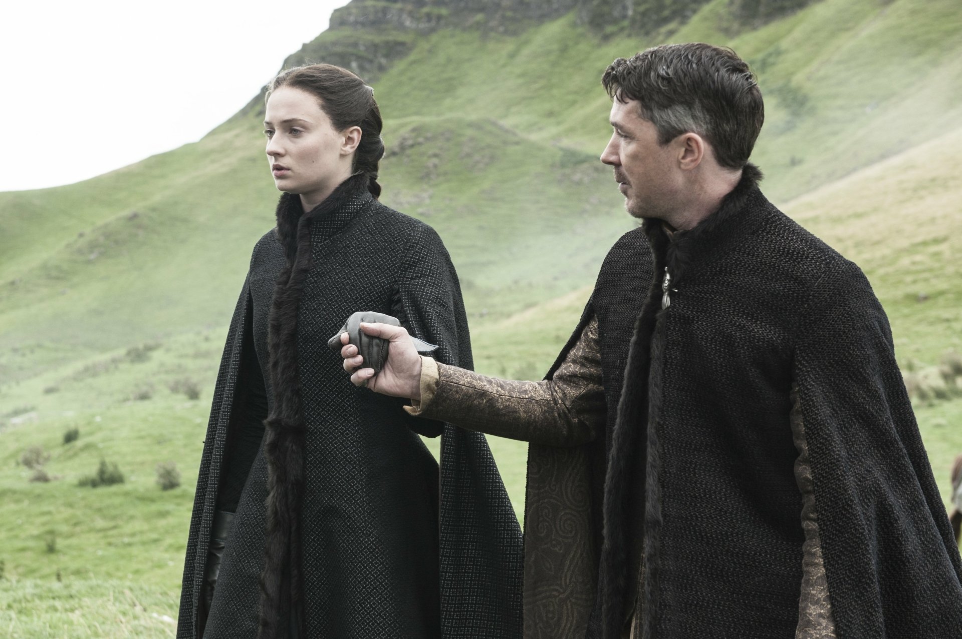 HD PC desktop wallpaper featuring Sophie Turner as Sansa Stark and Aidan Gillen as Petyr Baelish from the TV show Game of Thrones, set in a scenic outdoor landscape.