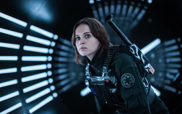 HD wallpaper featuring Jyn Erso (Felicity Jones) from Rogue One: A Star Wars Story, capturing her determined expression in a futuristic corridor with striking lighting.