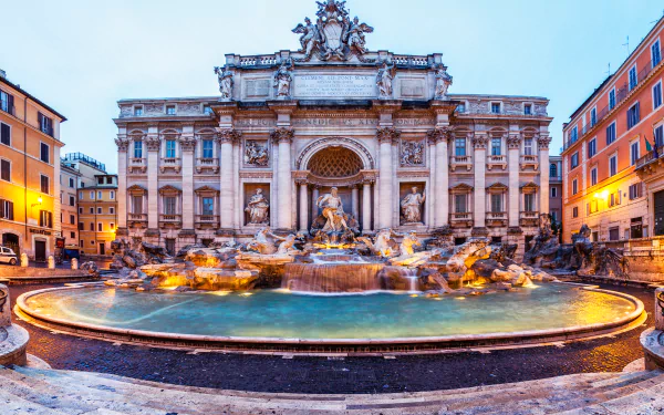 HD desktop wallpaper featuring the Trevi Fountain, a magnificent man-made statue and fountain in Rome, Italy, surrounded by historic buildings at dusk.