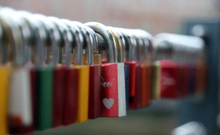 Close-up HD image of colorful man-made locks lined up, with a romantic heart detail and a blurred background, designed as a PC desktop wallpaper.