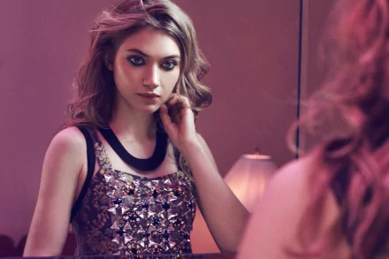 A stunning HD wallpaper featuring Imogen Poots, a brunette actress with captivating blue eyes, gazing thoughtfully in a mirror, exuding elegance and charm.