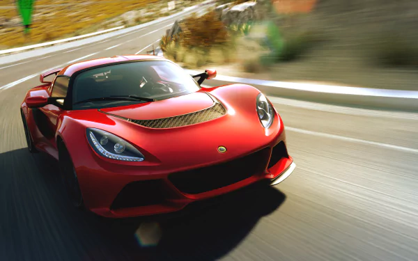 HD desktop wallpaper featuring a red Lotus Exige supercar speeding on a curvy road, showcasing its sleek design and dynamic motion.