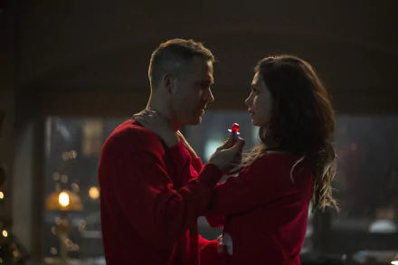 Morena Baccarin and Ryan Reynolds share a romantic moment in this HD wallpaper from the movie Deadpool, capturing their chemistry against a warm, cozy backdrop.