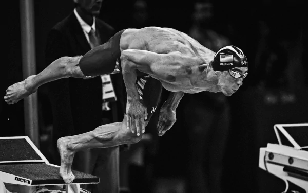A competitive swimmer diving off the starting block, captured in a dynamic black and white style, showcasing the intensity of swimming sports as an HD desktop wallpaper.