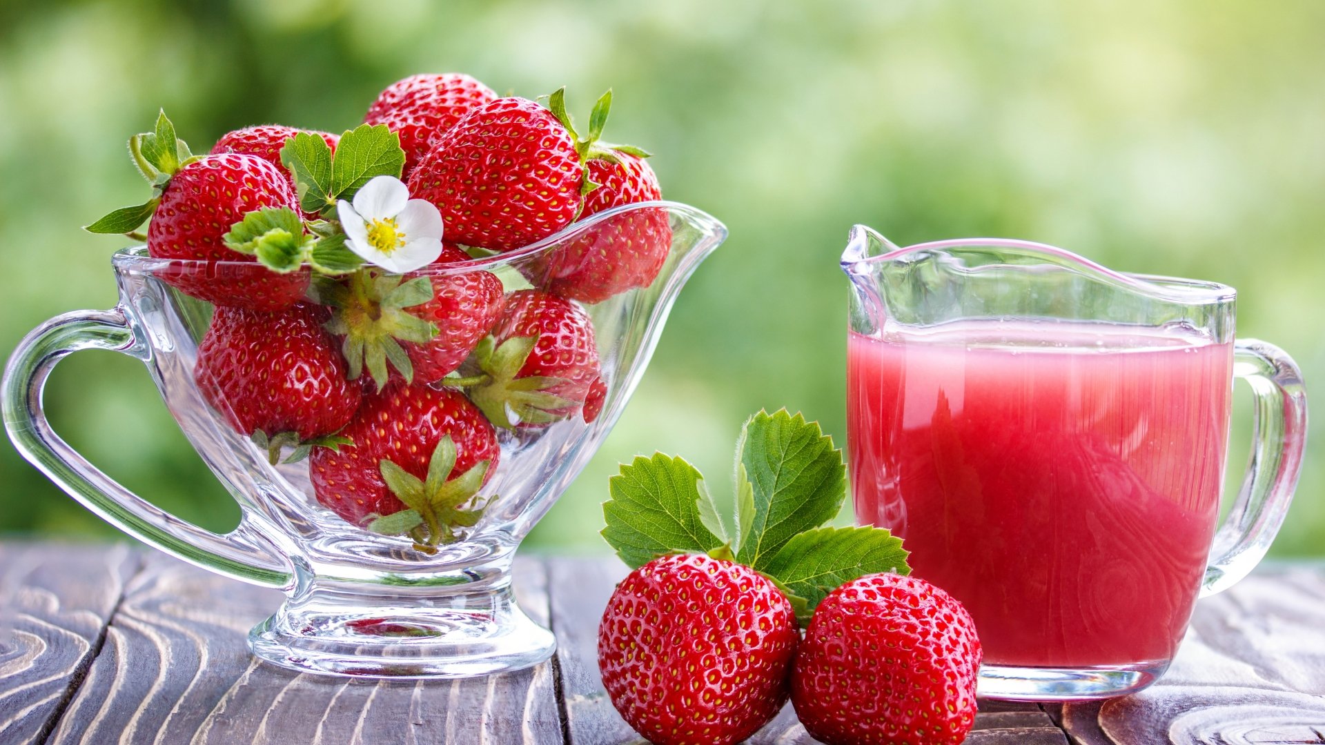 A vibrant 8K Ultra HD summer-themed image featuring fresh strawberries in a glass bowl alongside a glass of berry juice on a wooden surface with a blurred green background.