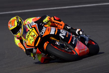 Close-up of a motorcycle racer leaning into a turn on the track, captured in vibrant detail for a 4K Ultra HD PC desktop wallpaper showcasing high-speed racing action.