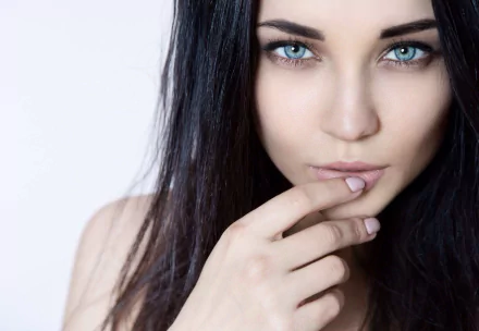 HD desktop wallpaper of a Ukrainian model with blue eyes and brunette hair, featuring a close-up of her face. The woman's thoughtful expression adds an elegant touch to the image.