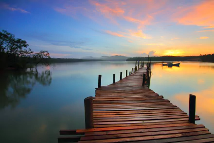 HD desktop wallpaper showing a serene sunrise over a man-made lake with a wooden pier extending into calm waters under a colorful sky.