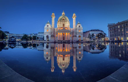 A stunning night view of Karlskirche in Vienna, Austria, beautifully reflected in still water, showcasing its architectural grandeur and serene ambiance.