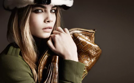 HD wallpaper of blonde English model and celebrity Cara Delevingne holding a stylish brown purse, showcasing a chic and sophisticated look.