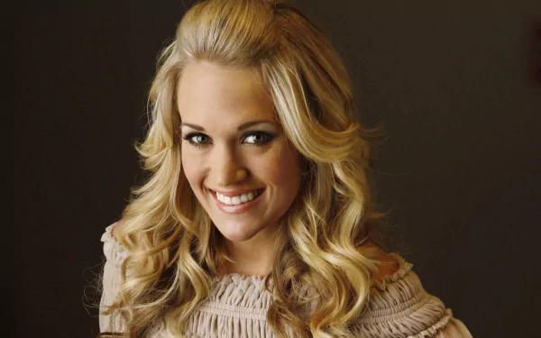 HD PC desktop wallpaper of Carrie Underwood with styled blonde hair, smiling against a dark background, highlighting her music career.