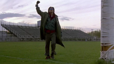 HD desktop wallpaper featuring Judd Nelson as John Bender from the movie The Breakfast Club, standing on a football field with his fist raised.