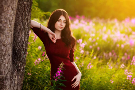 A brunette woman in a red dress poses stylishly outdoors near a tree, surrounded by blurred wildflowers in the sunny background, captured in HD for a desktop wallpaper.