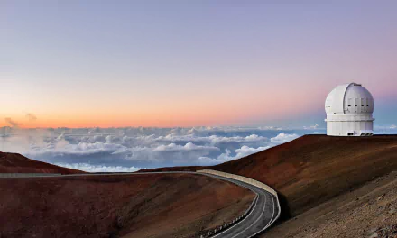 HD desktop wallpaper showing a winding road along a barren landscape under a colorful sky with clouds on the horizon and a man-made telescope dome.