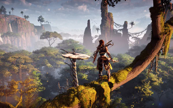 HD desktop wallpaper of Aloy from the video game Horizon Zero Dawn, standing on a mossy branch overlooking a lush, misty forest with tall rock formations in the distance.