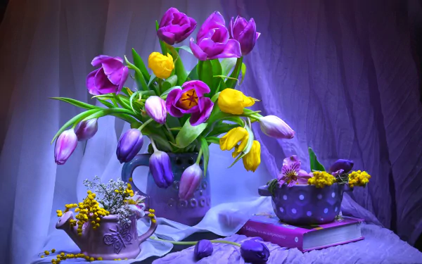 A stunning still life featuring vibrant purple and yellow tulips arranged in a pitcher, complemented by smaller floral displays, books, and a soft curtain backdrop.