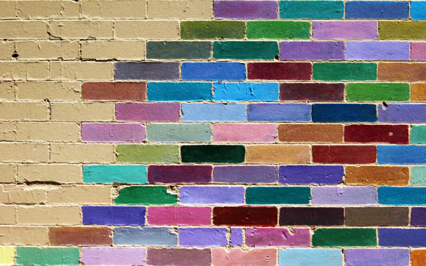 Vibrant colorful brick wall with textured paint in diverse hues, captured in high-resolution 4K Ultra HD photography, serving as a striking desktop wallpaper background.