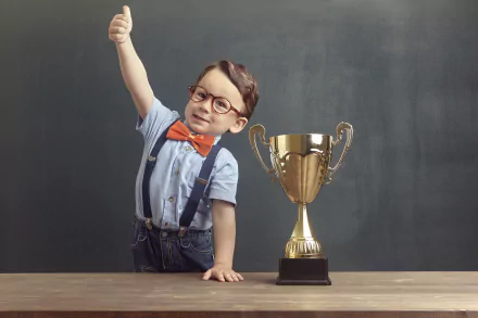 A child proudly raising a finger next to a trophy, designed as an HD desktop wallpaper and background.