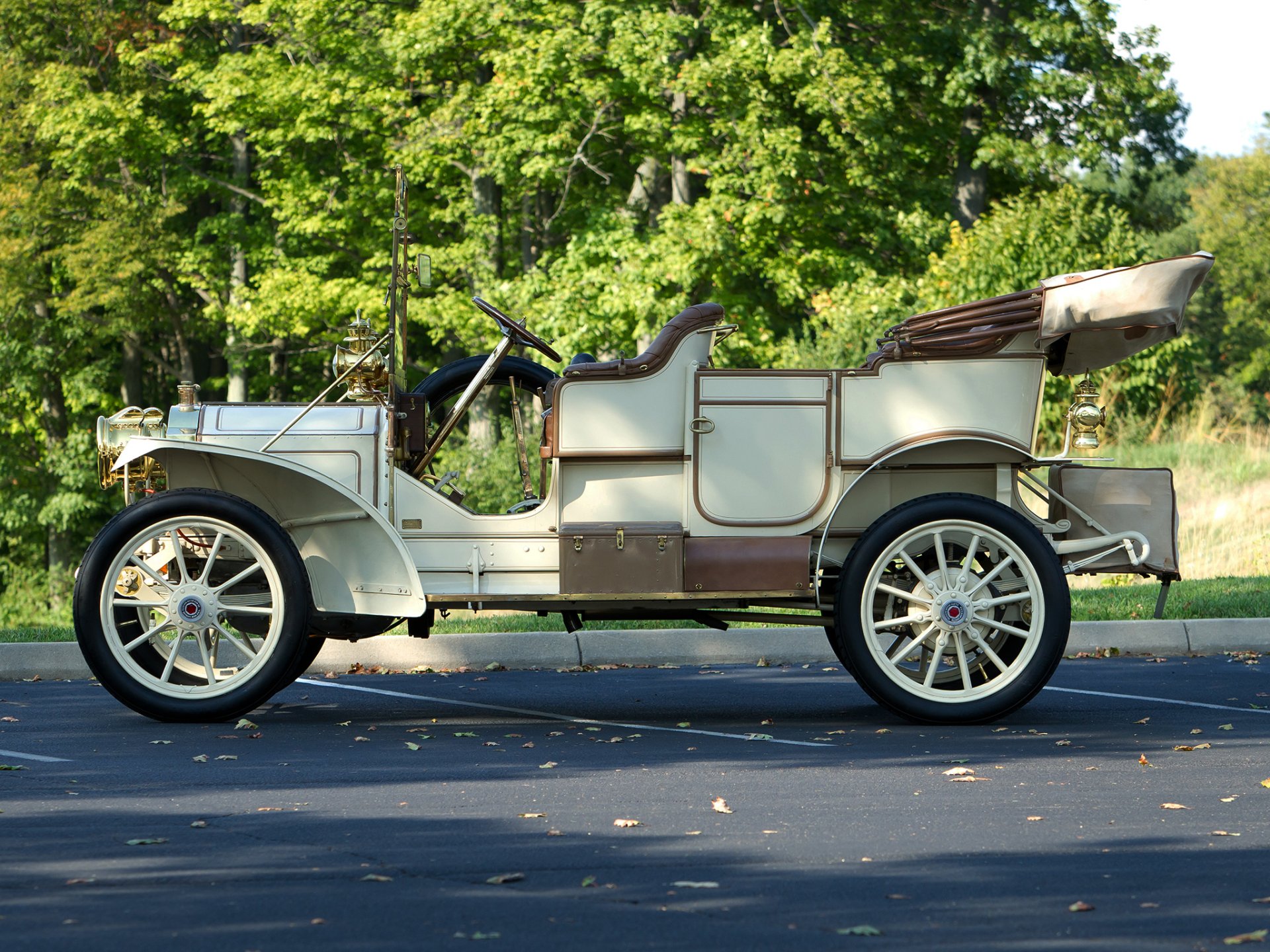 1909 Packard Model 18 Touring vintage car, cream open-top touring body in side profile against a leafy backdrop — HD PC desktop wallpaper.