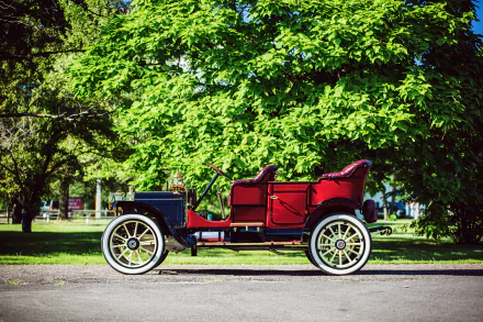 Red 1910 Packard Model 18 Touring NB vintage vehicle parked under leafy trees — 4K Ultra HD desktop wallpaper.