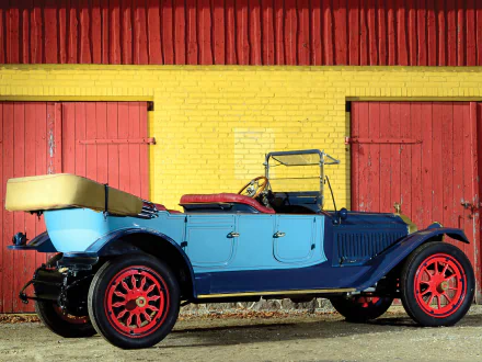 HD PC wallpaper featuring a vintage 1914 Packard Six 7-passenger Touring car, painted blue with red wheels, parked in front of a yellow brick wall and red doors.