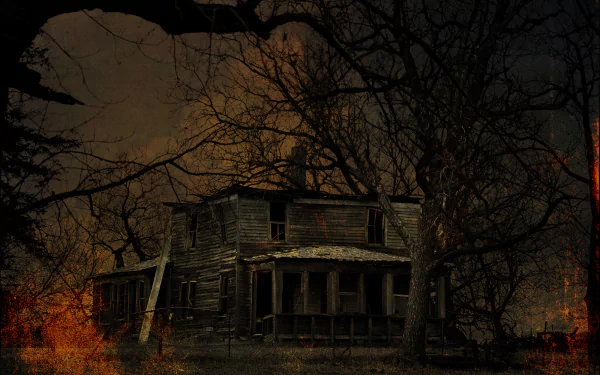HD desktop wallpaper of a dark, abandoned haunted house ruin surrounded by bare trees, evoking a spooky Halloween atmosphere.