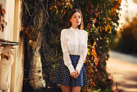 Olga Kobzar, a brunette model, stands outdoors wearing a white blouse and polka dot skirt, framed by autumn foliage in this HD PC desktop wallpaper and background.