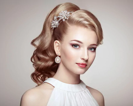 HD desktop wallpaper featuring a blonde woman with blue eyes and elegant earrings, showcasing a refined hairstyle with decorative hairpieces. The model's serene expression adds to the image's grace and sophistication.
