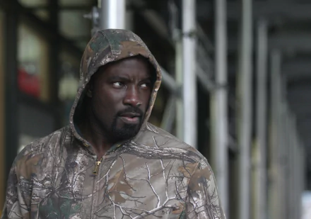 HD desktop wallpaper featuring a serious-looking man in a camouflage hoodie, suitable as a background image.