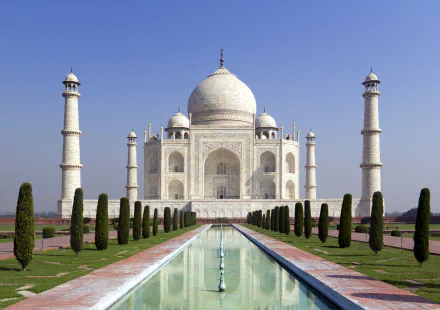 HD desktop wallpaper featuring the iconic Taj Mahal, a monumental dome structure in India, surrounded by lush green park grounds and a reflecting pool.