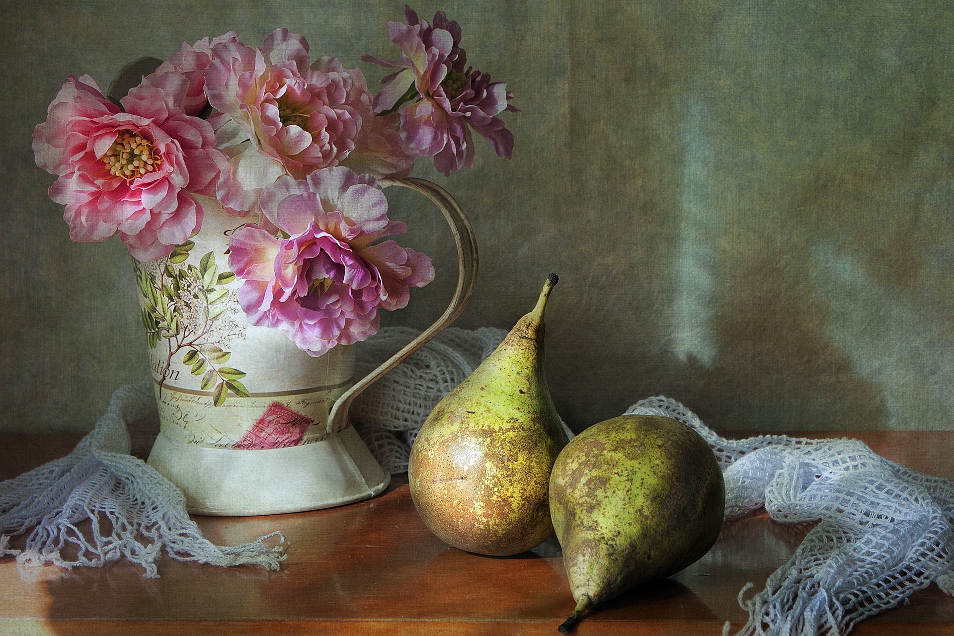 Still life HD desktop wallpaper featuring pink flowers in a decorated pitcher, two pears, and a lace scarf arranged on a wooden surface against a muted background.