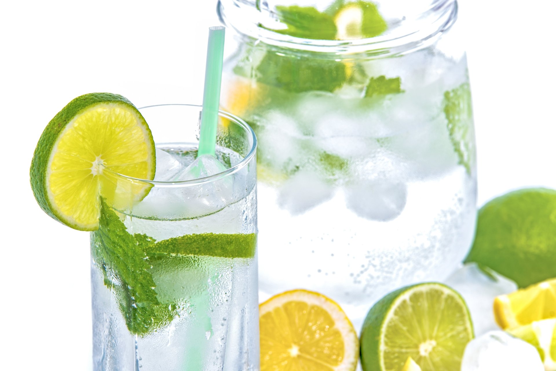 A refreshing glass and pitcher of ice-cold water infused with lime and mint, captured in crisp 4K Ultra HD as a vibrant PC desktop wallpaper.