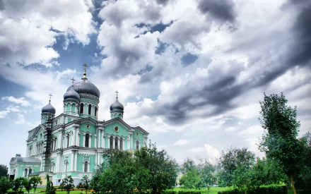 HD PC desktop wallpaper of a Russian religious cathedral with green domes set against dramatic cloudy skies.
