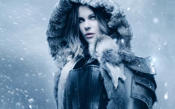 Kate Beckinsale as Selene from Underworld: Blood Wars, wearing a fur-lined hooded coat against a snowy backdrop, creates a striking HD wallpaper and background.