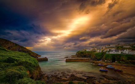HD desktop wallpaper of a Cornwall, England seaside village at the horizon, houses and boats gathered in a man-made harbor on the ocean.