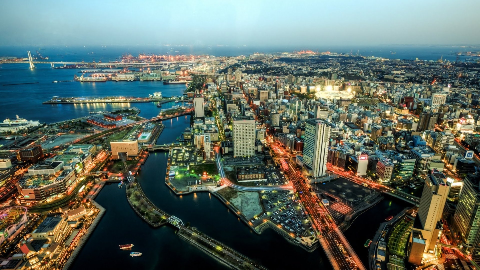Aerial Yokohama cityscape, Japan at dusk with illuminated harbor, bridges and skyscrapers — 2K Quad HD PC desktop wallpaper/background.