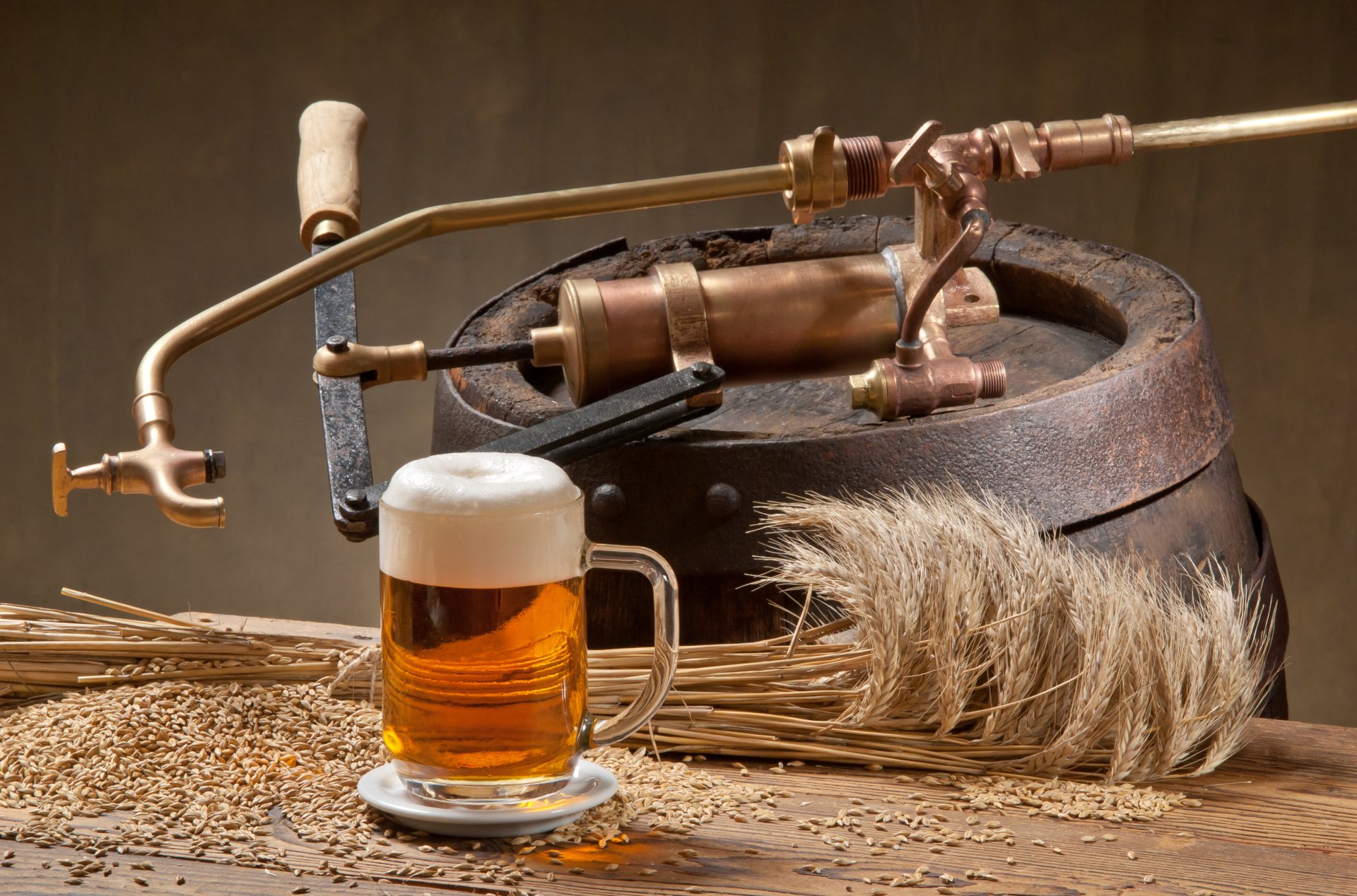 HD desktop wallpaper featuring a still life of a frothy glass of beer, a rustic barrel with a tap, and scattered grains and wheat, highlighting alcohol and drink themes.