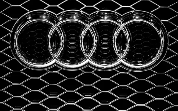 HD desktop wallpaper featuring the Audi logo with a black hexagonal pattern background.