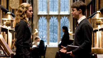 Emma Watson as Hermione Granger and Daniel Radcliffe as Harry Potter in a library scene from Harry Potter and the Half-Blood Prince. A HD desktop wallpaper showcasing characters in a school setting.