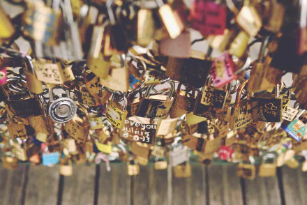 Romantic man-made lock installation captured in 4K Ultra HD, showcasing numerous padlocks symbolizing love and commitment as a striking desktop wallpaper background.