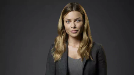 HD desktop wallpaper and background featuring a portrait of the actress in a gray blazer over a top with a subtle smile.