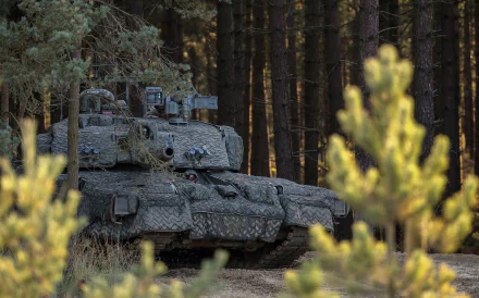 Challenger 2 military tank camouflaged among pine trees in a forest — HD PC desktop wallpaper background.
