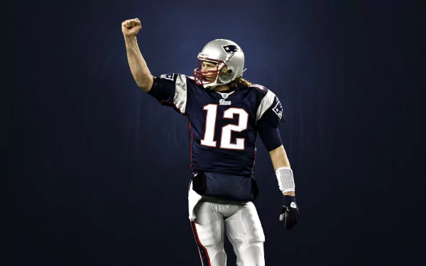 An HD desktop wallpaper featuring Tom Brady in a dynamic pose, wearing his New England Patriots jersey, celebrating with a clenched fist. A striking background enhances the sports theme.