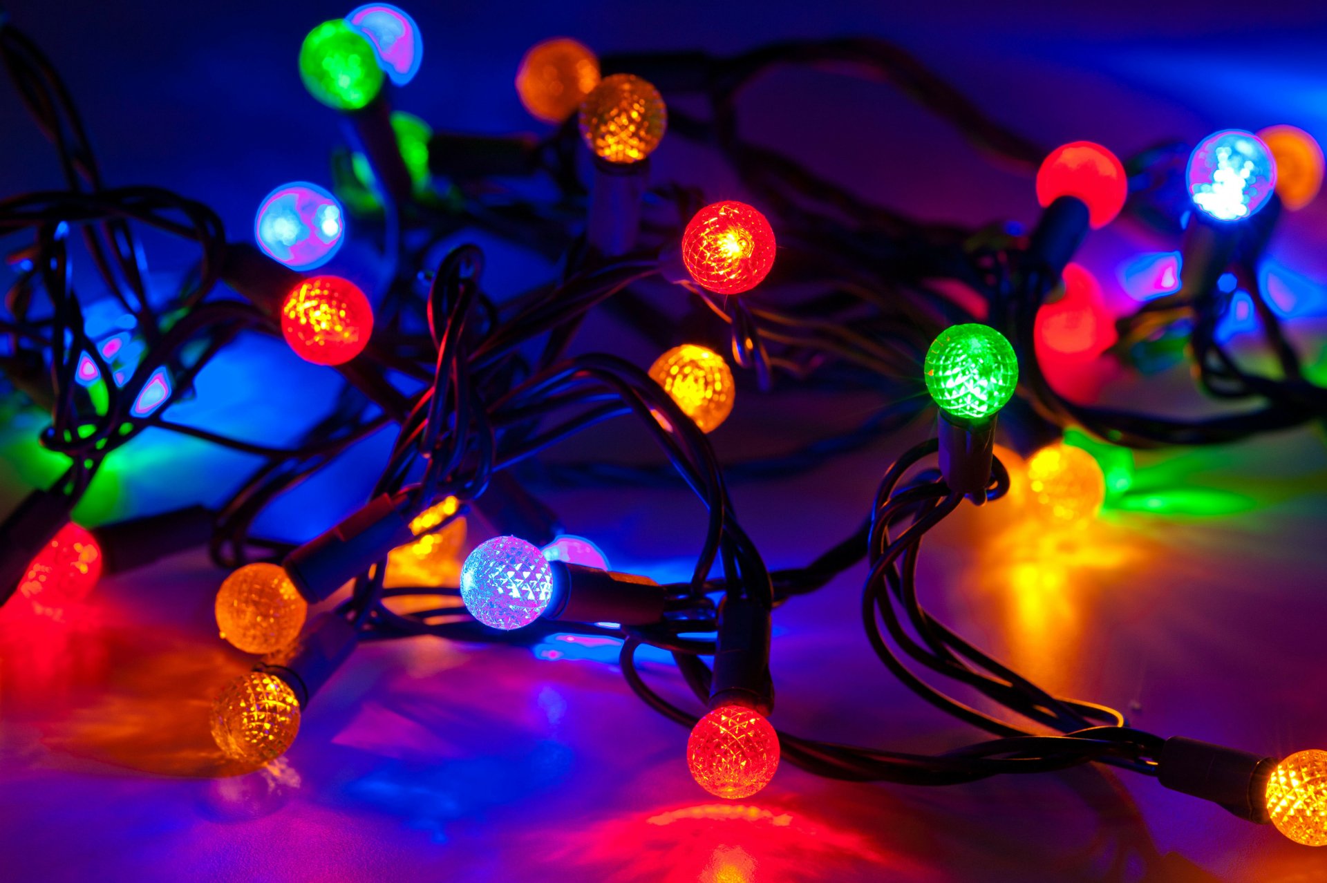 Colorful Christmas lights glowing in vibrant red, green, blue, and yellow hues on a dark background, captured in 4K Ultra HD for a festive PC desktop wallpaper.