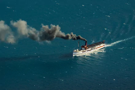 A steamboat emits thick smoke as it moves through the ocean, captured in this HD desktop wallpaper featuring a classic vehicle on deep blue water.
