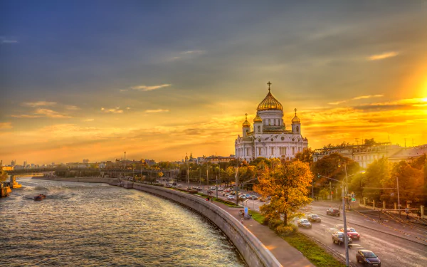 HDR view of the Cathedral of Christ the Saviour in Moscow, Russia, beside a river under a vivid sunset sky, captured as a high-definition desktop wallpaper.