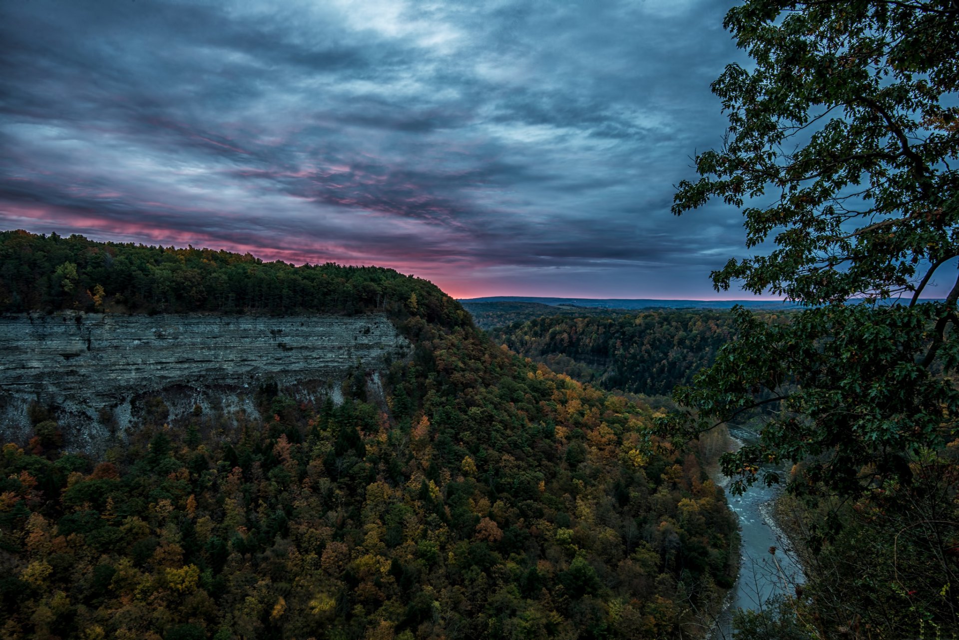 HD PC desktop wallpaper and background: panoramic nature landscape of Letchworth State Park and Wyoming — river winding through forested canyon and mountain cliffs under dramatic clouds.