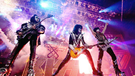 HD wallpaper featuring the band KISS performing live with striking glam metal and heavy metal elements, amidst vibrant stage lights and special effects.